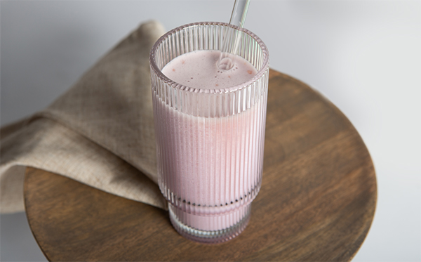 berry smoothie meal replacement in a glass with a straw