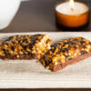 Two halves of a chocolate peanut meal replacement bar