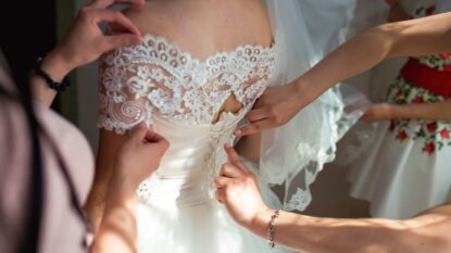 Lady in wedding dress having the back buttoned up